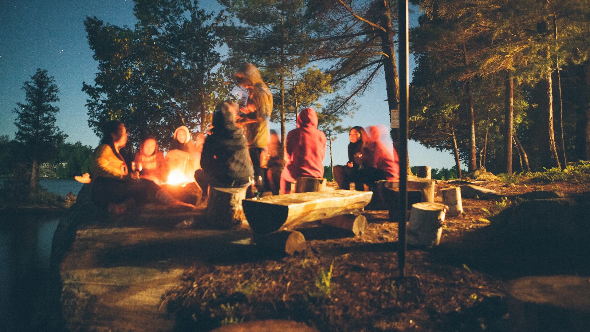 Campfire beside tent on lake shore